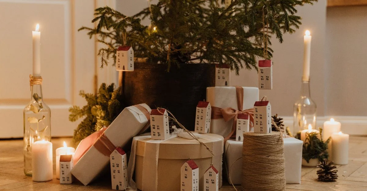Une pièce chaleureuse et festive avec un arbre de Noël décoré et des cadeaux éclairés à la bougie.
